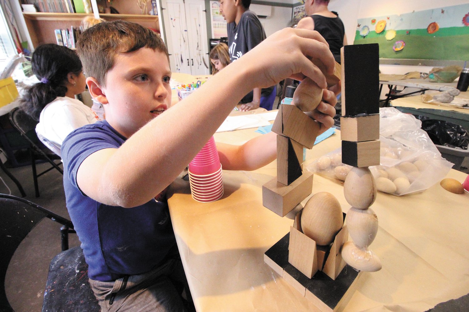CUBIST SCULPTURE: Emmett Revens looks to made additions to his block tower.